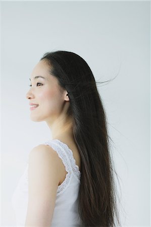 simsearch:622-06964327,k - Young woman with long hair smiling Fotografie stock - Premium Royalty-Free, Codice: 622-06964292