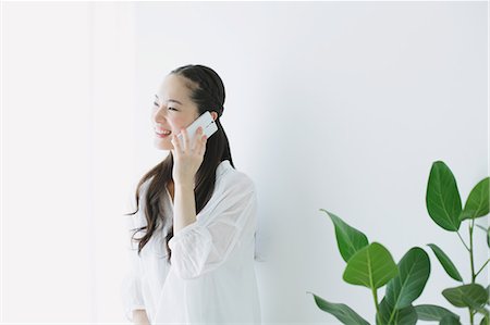 simsearch:859-06824638,k - Young woman on the phone in the living room Fotografie stock - Premium Royalty-Free, Codice: 622-06964316