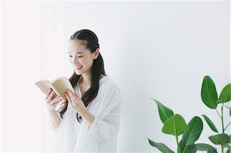 simsearch:622-06964281,k - Young woman with book in the living room Stock Photo - Premium Royalty-Free, Code: 622-06964319