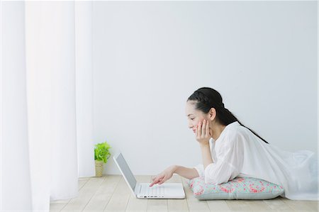 floor cushion - Young woman with laptop in the living room Stock Photo - Premium Royalty-Free, Code: 622-06964328