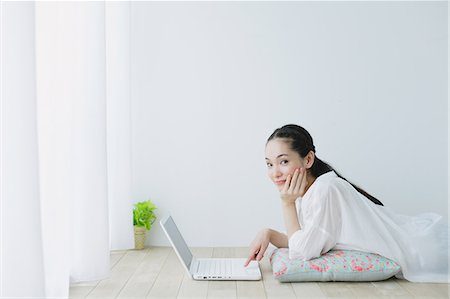 pillow wall - Young woman with laptop in the living room Photographie de stock - Premium Libres de Droits, Code: 622-06964329