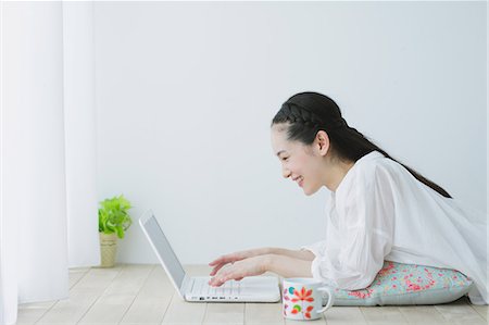 simsearch:622-06964327,k - Young woman with laptop in the living room Fotografie stock - Premium Royalty-Free, Codice: 622-06964330