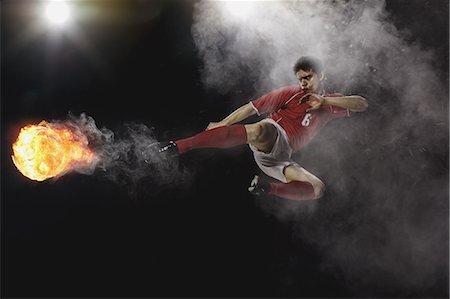 soccer jump - Soccer Player Kicking The Ball In Mid-Air Stock Photo - Premium Royalty-Free, Code: 622-07736025