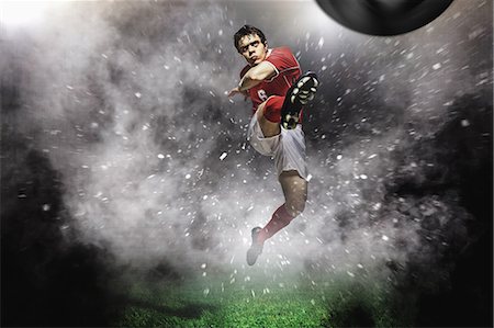 Soccer Player Kicking The Ball In Mid-Air Foto de stock - Sin royalties Premium, Código: 622-07736026