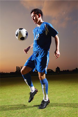 soccer games - Football player in a blue uniform lifting ball Stock Photo - Premium Royalty-Free, Code: 622-07736079