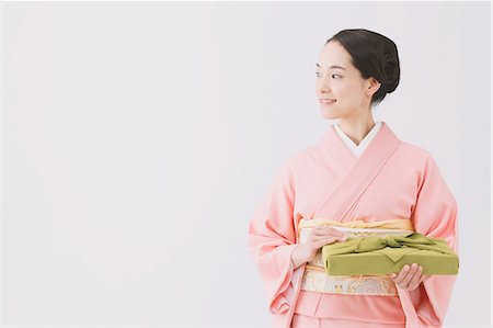 Young Japanese woman in a traditional kimono against white background Stock Photo - Premium Royalty-Free, Code: 622-07743561