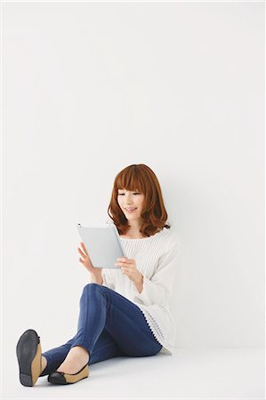 people white background computer not head and shoulders not waist up not one - Full length portrait of young Japanese woman against white background Stock Photo - Premium Royalty-Free, Code: 622-07810763