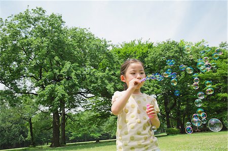 Japanese kid playing with soap bubbles in a park Foto de stock - Sin royalties Premium, Código: 622-08007083