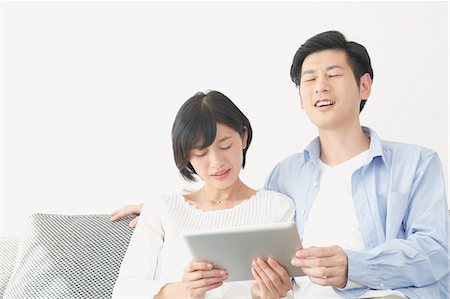 people at home white background - Japanese couple on the sofa with tablet Stock Photo - Premium Royalty-Free, Code: 622-08122675