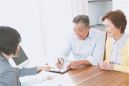 relief - Senior Japanese couple consulting with financial planner Stock Photo - Premium Royalty-Free, Code: 622-08122709
