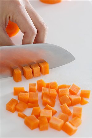Close up of woman's hands slicing carrots with a kitchen knife Stock Photo - Premium Royalty-Free, Code: 622-08138921