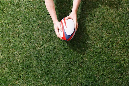 simsearch:622-08355398,k - Man holding rugby ball on grass Foto de stock - Sin royalties Premium, Código: 622-08355397