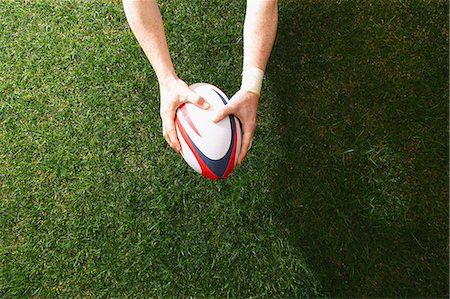 rugby - Man holding rugby ball on grass Photographie de stock - Premium Libres de Droits, Code: 622-08355398