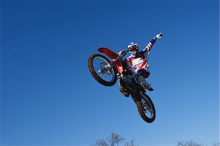 Motocross biker jumping over dirt track Foto de stock - Sin royalties Premium, Código: 622-08355497