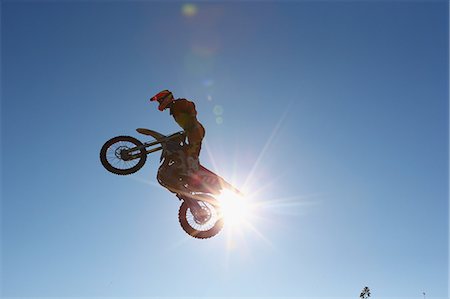 Motocross biker jumping over dirt track Foto de stock - Sin royalties Premium, Código: 622-08355597