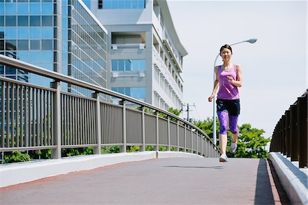 simsearch:622-08355688,k - Young Japanese woman running downtown Tokyo Photographie de stock - Premium Libres de Droits, Code: 622-08355655