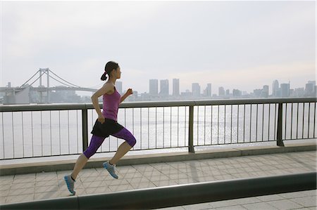 simsearch:622-08355688,k - Young Japanese woman running downtown Tokyo Photographie de stock - Premium Libres de Droits, Code: 622-08355929