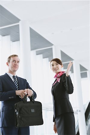 Japanese attractive flight attendant helping customer at the airport Stock Photo - Premium Royalty-Free, Code: 622-08482487