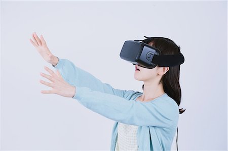 Japanese woman using virtual reality device Stock Photo - Premium Royalty-Free, Code: 622-08519693