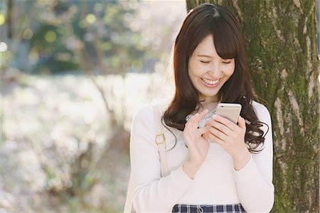 simsearch:859-06538080,k - Young Japanese woman with smartphone in a city park Stock Photo - Premium Royalty-Free, Code: 622-08542963