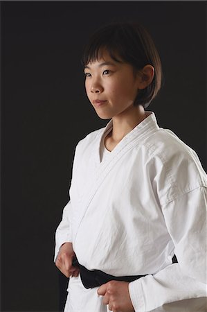 eyes looking away - Japanese kid in karate uniform on black background Stock Photo - Premium Royalty-Free, Code: 622-08657696