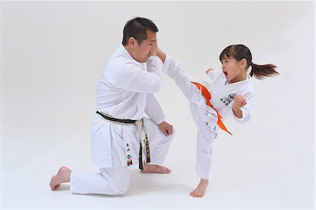 Japanese kid in karate uniform training with teacher on white background Stock Photo - Premium Royalty-Free, Code: 622-08657825