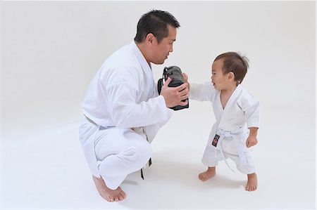 simsearch:622-08657807,k - Japanese kid in karate uniform training with teacher on white background Stock Photo - Premium Royalty-Free, Code: 622-08657833