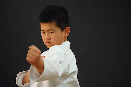 preteen child modeling - Japanese kid in karate uniform on black background Stock Photo - Premium Royalty-Free, Code: 622-08657856