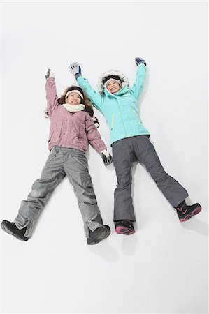 directly above lying woman full length - Young Japanese women wearing snowboard wear on white background Stock Photo - Premium Royalty-Free, Code: 622-08765644