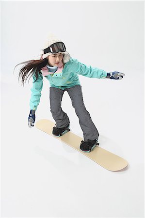 sports and snowboarding - Young Japanese woman wearing snowboard wear on white background Stock Photo - Premium Royalty-Free, Code: 622-08765655