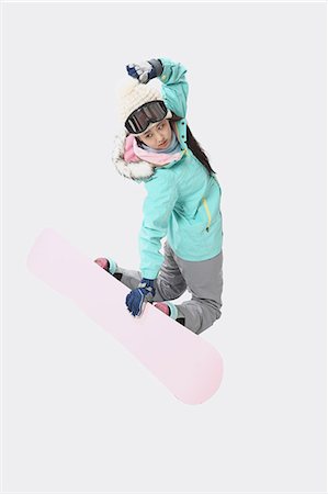 Young Japanese woman wearing snowboard wear on white background Stock Photo - Premium Royalty-Free, Code: 622-08765659