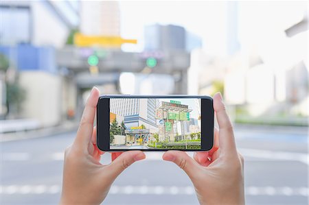 Japanese woman using augumented reality app on smartphone downtown Tokyo, Japan Foto de stock - Sin royalties Premium, Código: 622-08839816