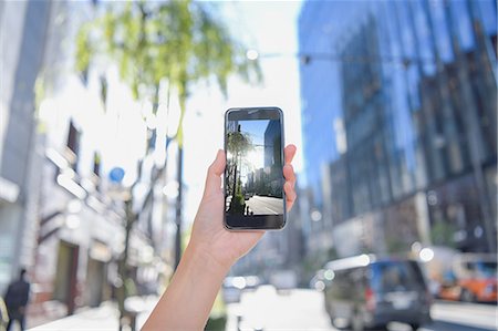 Japanese woman using augumented reality app on smartphone downtown Tokyo, Japan Stock Photo - Premium Royalty-Free, Code: 622-08839820