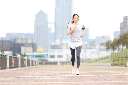 running with headphones - Attractive Japanese woman training by a river downtown Tokyo, Japan Stock Photo - Premium Royalty-Free, Code: 622-08839865