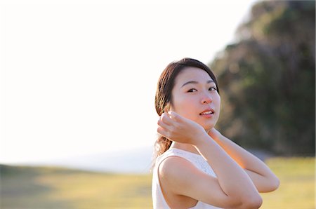 Young Japanese woman in a white dress at a cliff over the sea at sunrise, Chiba, Japan Stock Photo - Premium Royalty-Free, Code: 622-08949145