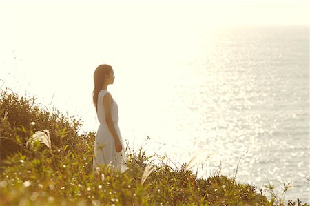 Young Japanese woman in a white dress at a cliff over the sea at sunrise, Chiba, Japan Photographie de stock - Premium Libres de Droits, Code: 622-08949303