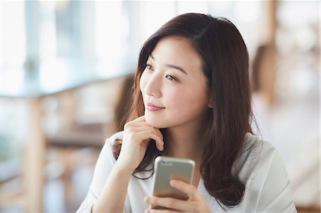 simsearch:622-09014723,k - Japanese woman with smartphone in a stylish cafe Foto de stock - Royalty Free Premium, Número: 622-09014317