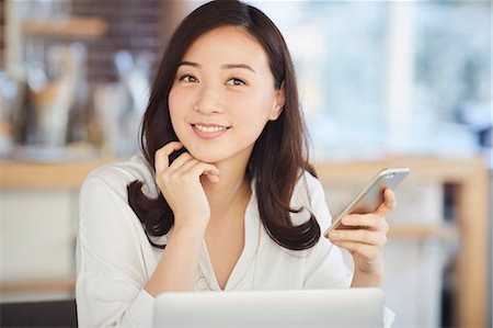 Japanese woman with smartphone in a stylish cafe Photographie de stock - Premium Libres de Droits, Code: 622-09014339