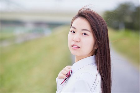 Cute Japanese high school student in a city park Stock Photo - Premium Royalty-Free, Code: 622-09138614