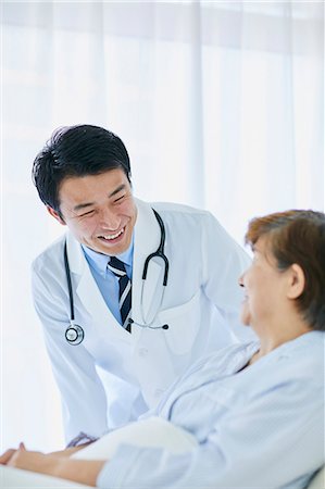 Japanese doctor with a patient in bed Foto de stock - Sin royalties Premium, Código: 622-09169696