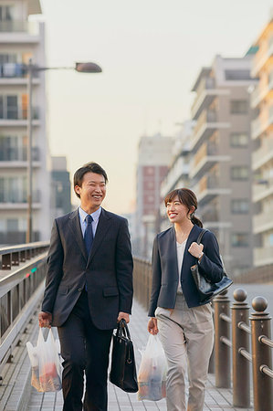 Japanese couple commuting home from work Stock Photo - Premium Royalty-Free, Code: 622-09175803