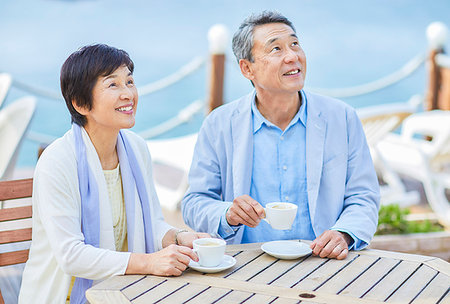 Japanese senior couple having a drink by the sea Stock Photo - Premium Royalty-Free, Code: 622-09176218