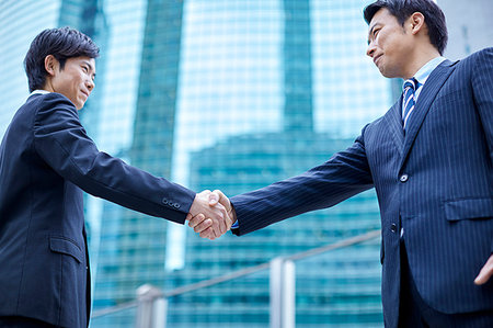 Japanese businesspeople shaking hands downtown Tokyo Stock Photo - Premium Royalty-Free, Code: 622-09180955