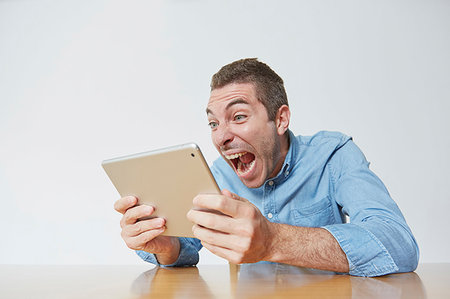 digital tablet and shocked and one person - Caucasian man using tablet Stock Photo - Premium Royalty-Free, Code: 622-09236022