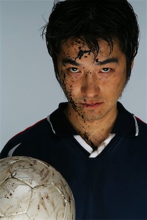 Soccer player with face covered in mud Stock Photo - Premium Royalty-Free, Code: 622-00701403