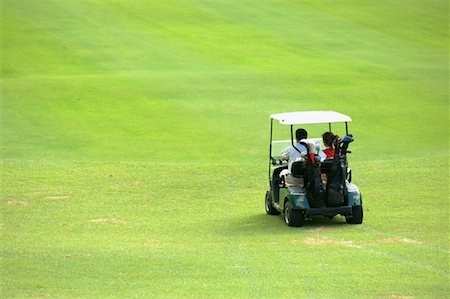 Rear view of two golfers sitting in a golf cart Stock Photo - Premium Royalty-Free, Code: 622-00807008