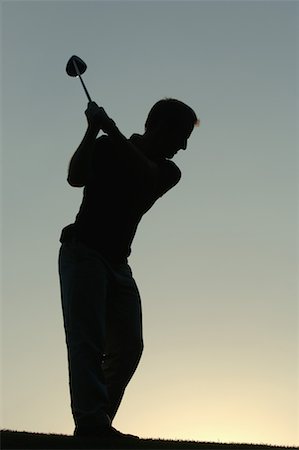 Silhouette of a man in action hitting a golf shot Stock Photo - Premium Royalty-Free, Code: 622-00807034