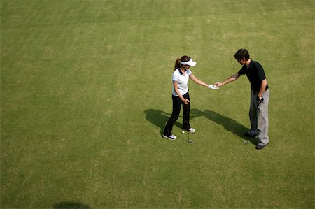 Man passing a golf ball to a woman Stock Photo - Premium Royalty-Free, Code: 622-00807142