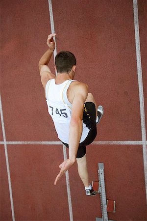 simsearch:622-00947146,k - Male Runner Leaping Off Starting Blocks Stock Photo - Premium Royalty-Free, Code: 622-00947156