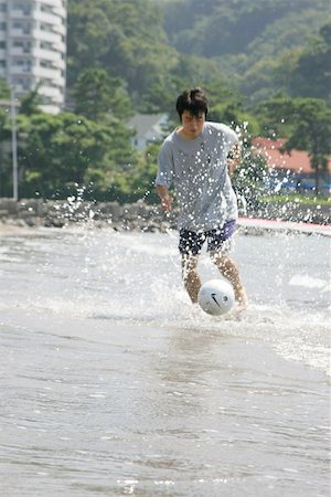 simsearch:622-01080599,k - Young Man Playing Soccer On A Beach Foto de stock - Sin royalties Premium, Código: 622-00947341